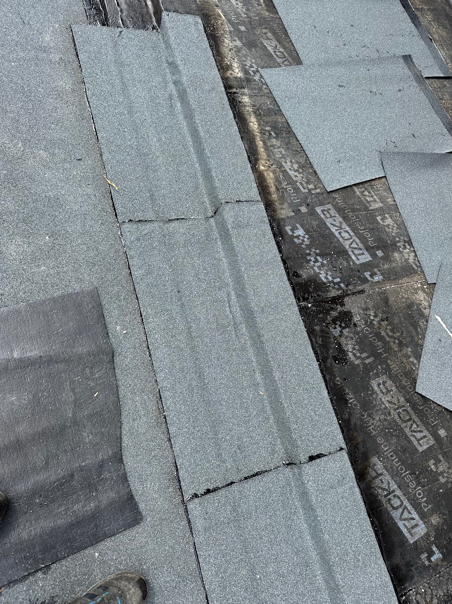 Fragment dachu pokrytego papą termozgrzewalną, widoczne łączenia i warstwa hydroizolacyjna z logo producenta.