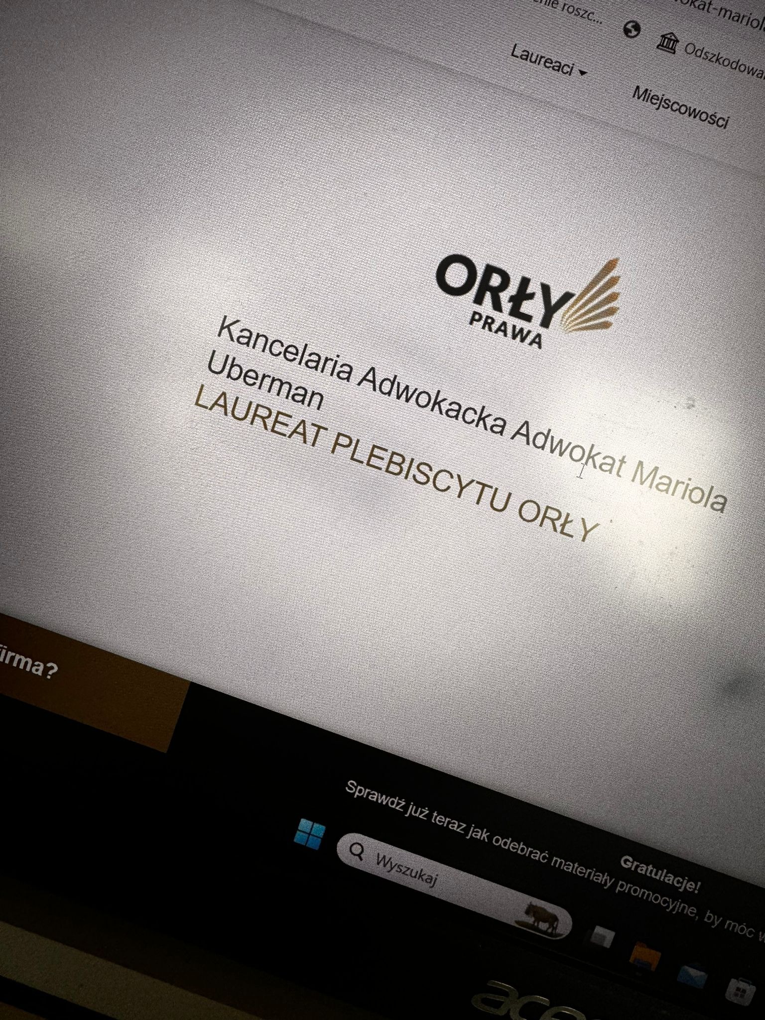 Ekran laptopa wyświetlający logo i nazwę Kancelarii Adwokackiej Uberman oraz informację o zdobyciu nagrody Laureat Plebiscytu Orły Prawa.