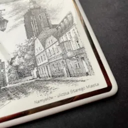 Ręcznie rysowany szkic starego miasta Namysłów na ceramicznej płytce z brązowym obramowaniem.