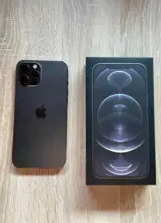 Czarny iPhone 12 Pro w matowym etui obok pudełka na drewnianym stole.