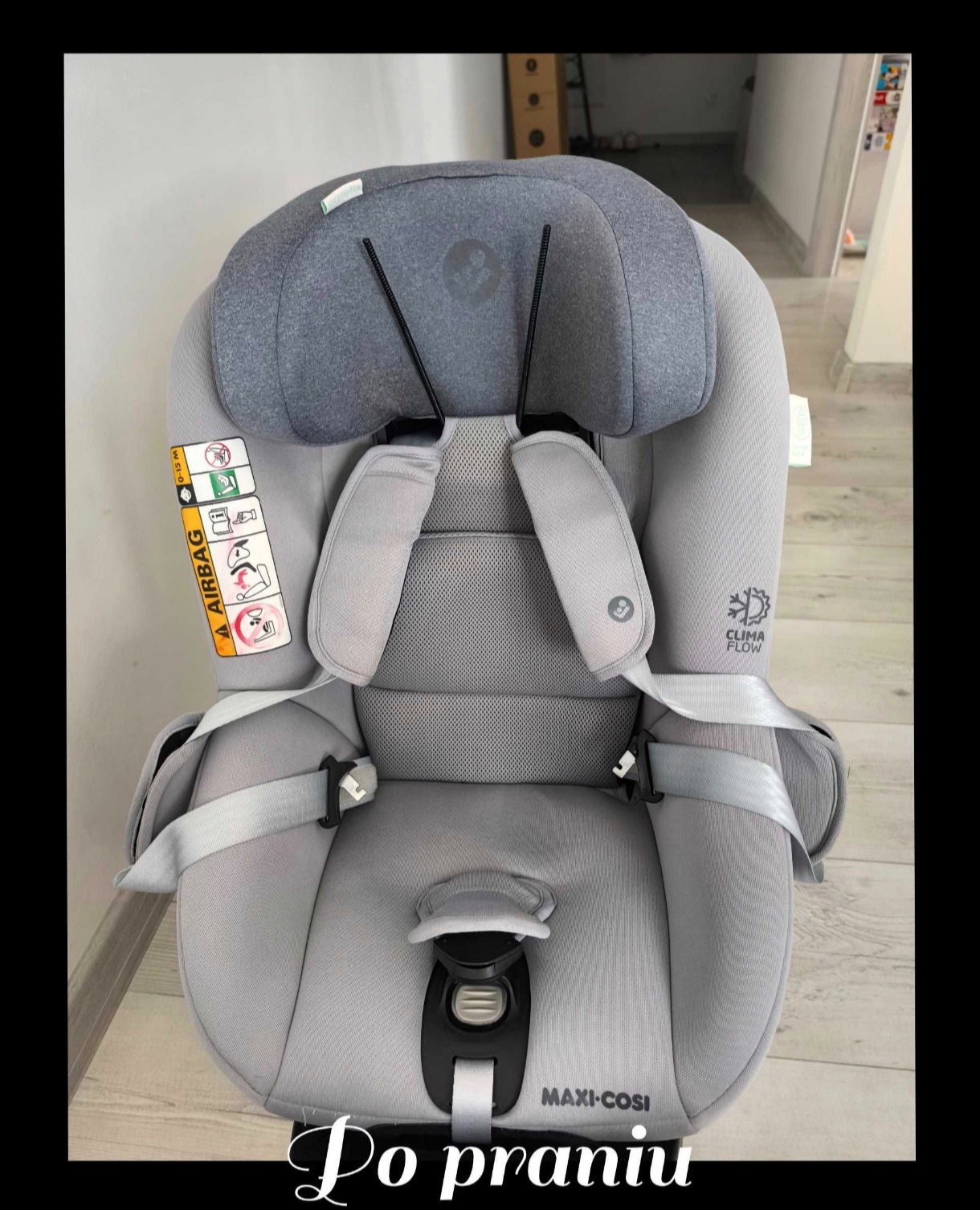 Szary fotelik samochodowy Maxi-Cosi z widocznymi elementami tapicerki i pasami bezpieczeństwa, po czyszczeniu, z naklejkami informacyjnymi i systemem Clima Flow.