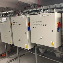 KLIMAZEN SPÓŁKA Z OGRANICZONĄ ODPOWIEDZIALNOŚCIĄ - Szereg szaf sterowniczych z oznaczeniami SALA A, SALA B, SALA C, połączonych z kanałem wentylacyjnym w pomieszczeniu technicznym.