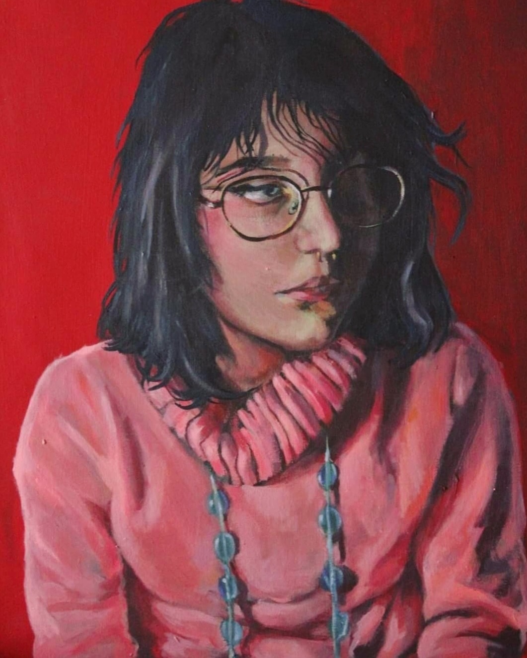 Portret olejny młodej kobiety w okularach, z ciemnymi włosami, ubranej w różowy sweter z golfem i naszyjnik z niebieskich koralików, na czerwonym tle.