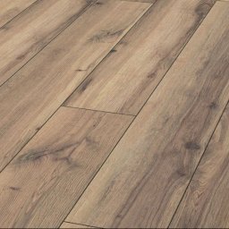 Renowacja Łukaszewicz - Ułożone panele podłogowe w odcieniach jasnego brązu z wyraźnym rysunkiem drewna, widoczne łączenia między panelami, ułożone pod kątem.