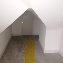 Łukasz szydlik - Poddasze po odświeżeniu, pomalowane na biało, z zabezpieczoną folią podłogą i wejściem do schowka pod skosem dachu.