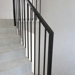 Balustrada z pochwytem 40x40 mm i wypełnieniem 15x15 mm. Tralki mocowane bezpośrednio do ściany, bez dolnego profilu, nadają konstrukcji lekkości. Całość dopełnia dolna harfa z profilu 15x15 mm, mocowana do boku.