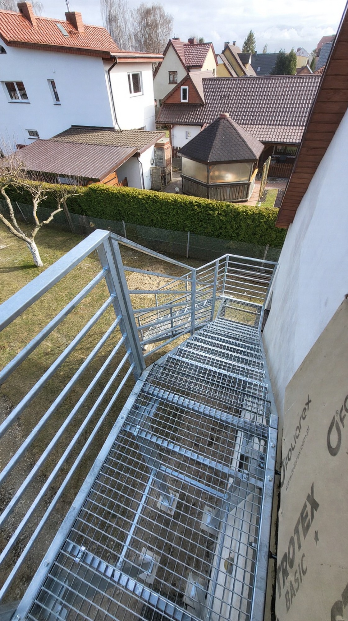 Zewnętrzne schody metalowe z balustradą, ocynkowane ogniowo, z kratą WEMA, widok z góry w Koszalinie. Solidna konstrukcja, nowoczesny design.