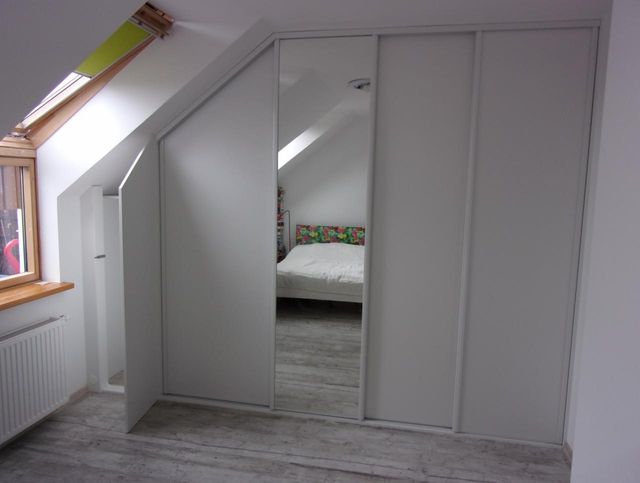 Biała szafa przesuwna z lustrem w pokoju na poddaszu w Szczecinie, widoczna część łóżka w odbiciu lustra.