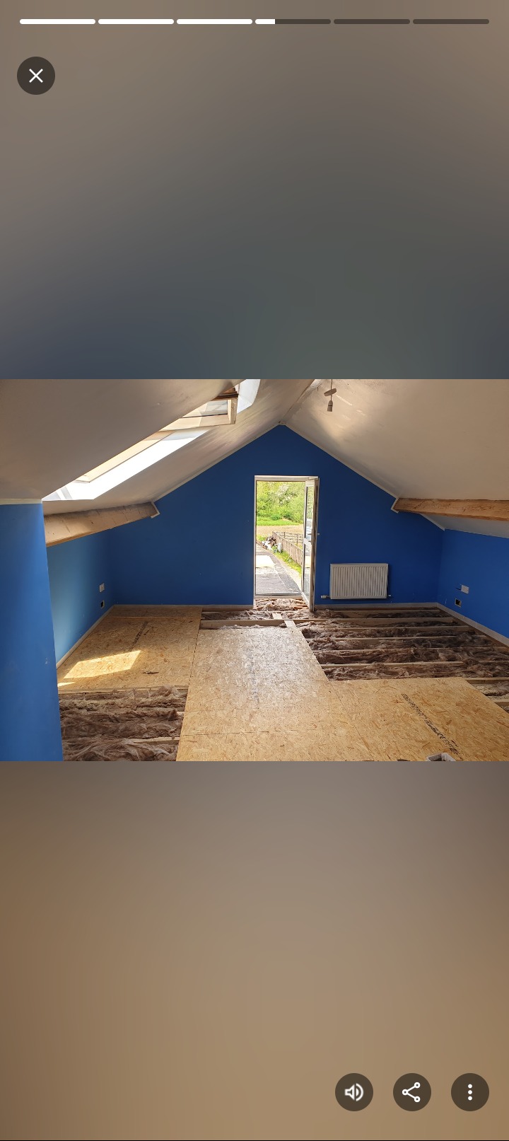 Poddasze w trakcie adaptacji: widoczne ocieplenie wełną mineralną między legarami i płyty OSB na podłodze. Ściany pomalowane na niebiesko, okno dachowe.