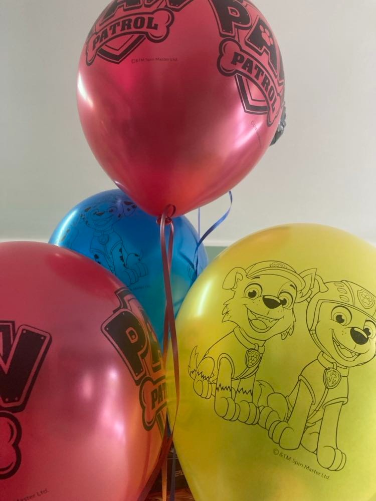 Bukiet czterech balonów: czerwony, żółty i niebieski, z nadrukami postaci z bajki Psi Patrol.