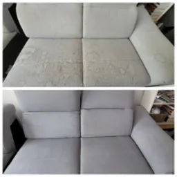 Dwuetapowe ujęcie szarej, tapicerowanej sofy: widoczne plamy i zabrudzenia na górnej połowie zdjęcia, dolna połowa prezentuje sofę po czyszczeniu, ukazując jednolitą, czystą powierzchnię.