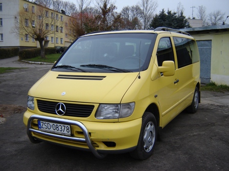 Żółty Mercedes Vito z orurowaniem na parkingu, widok z przodu, tablica rejestracyjna ZSD 08378.