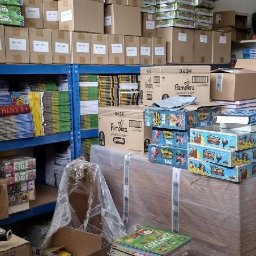 PACKMANS - Książki i kartony spakowane i przygotowane do transportu, regały z książkami w tle.