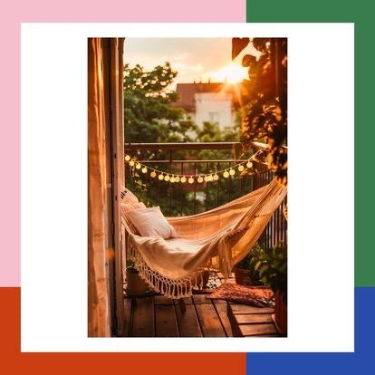 Przytulny balkon z hamakiem w beżowych odcieniach, oświetlony girlandą żarówek, z widokiem na zachodzące słońce i zieleń drzew.