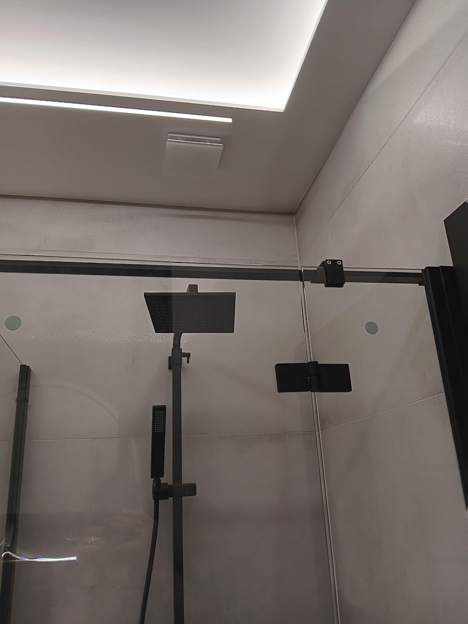 Nowoczesna kabina prysznicowa z czarnymi elementami i deszczownicą, oświetlenie LED w suficie, Rzeszów. Minimalistyczny design, szklane ściany.