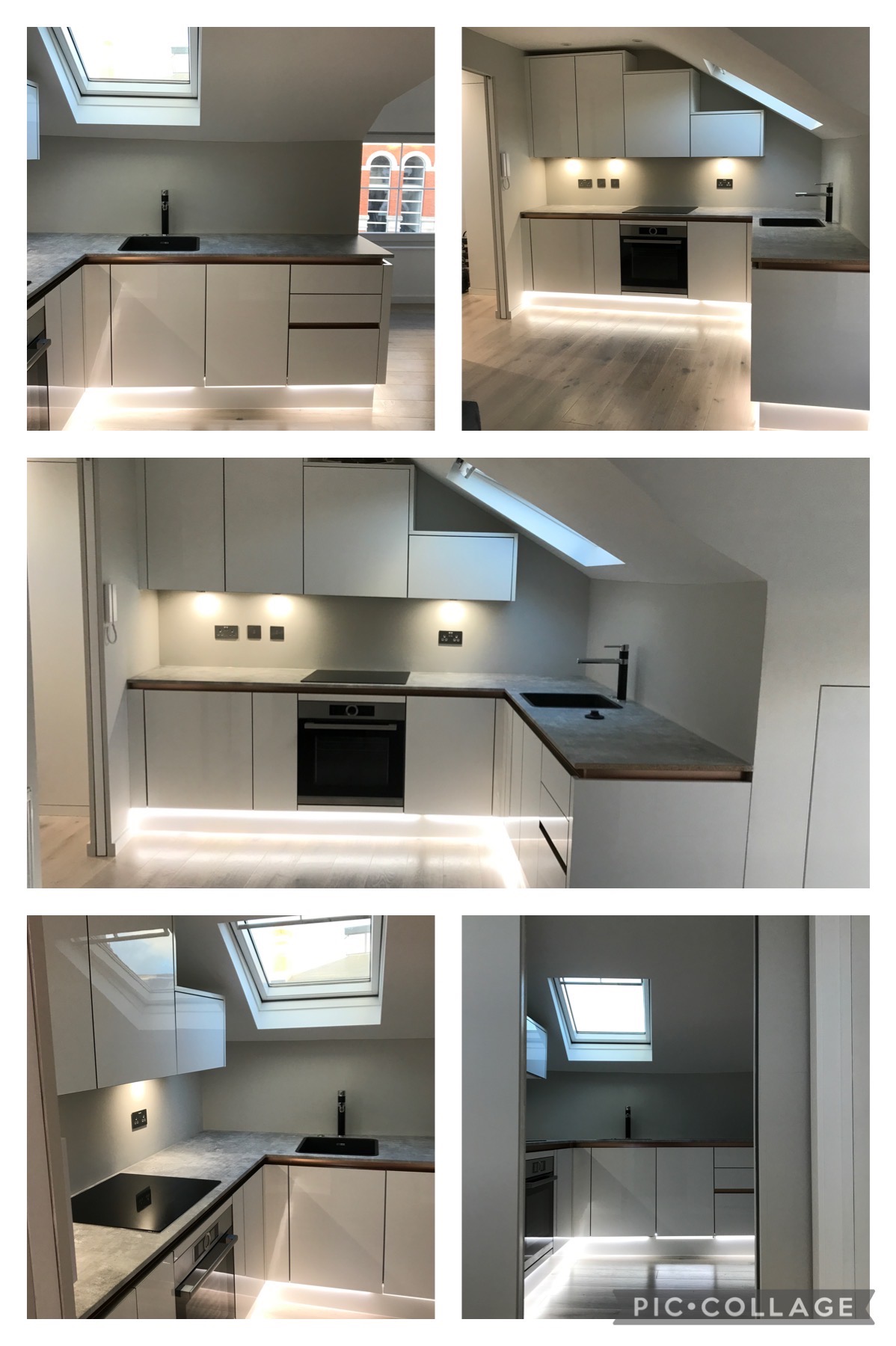 Nowoczesna kuchnia na poddaszu z białymi, lakierowanymi frontami szafek, szarym blatem i oświetleniem LED pod szafkami, z widocznym oknem dachowym i fragmentem budynku za oknem.