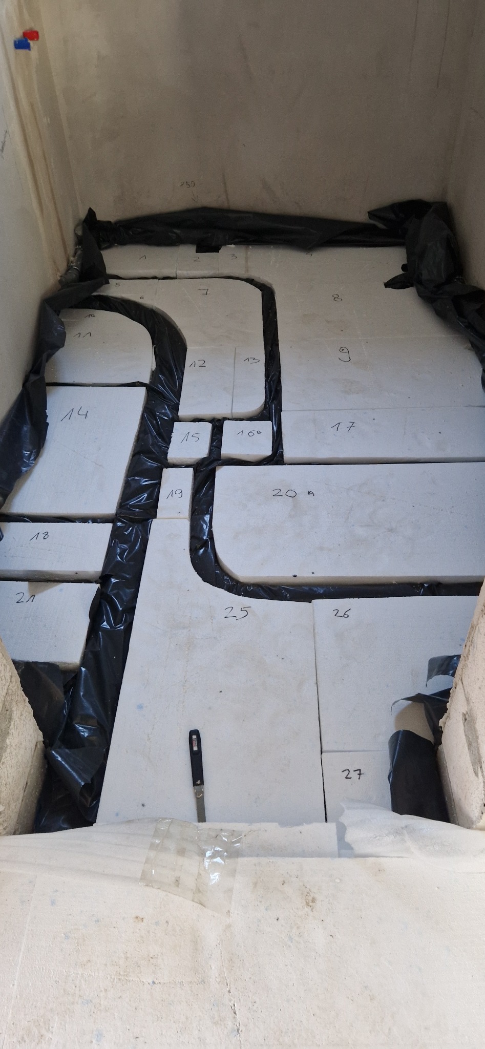 Układanie styropianu wraz z folią podposadzkową pod ogrzewanie podłogowe.