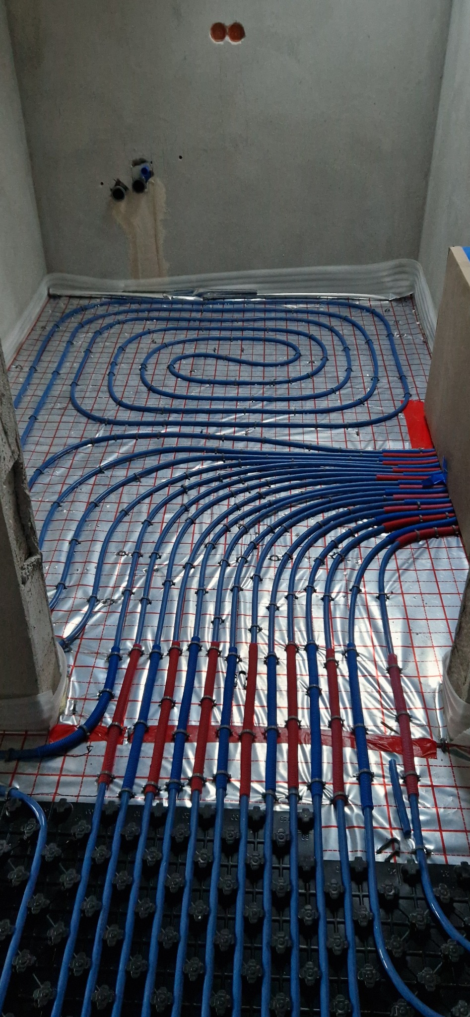 Wyjście pętli ogrzewania podłogowego ze skrzynki z rozdzielaczem.