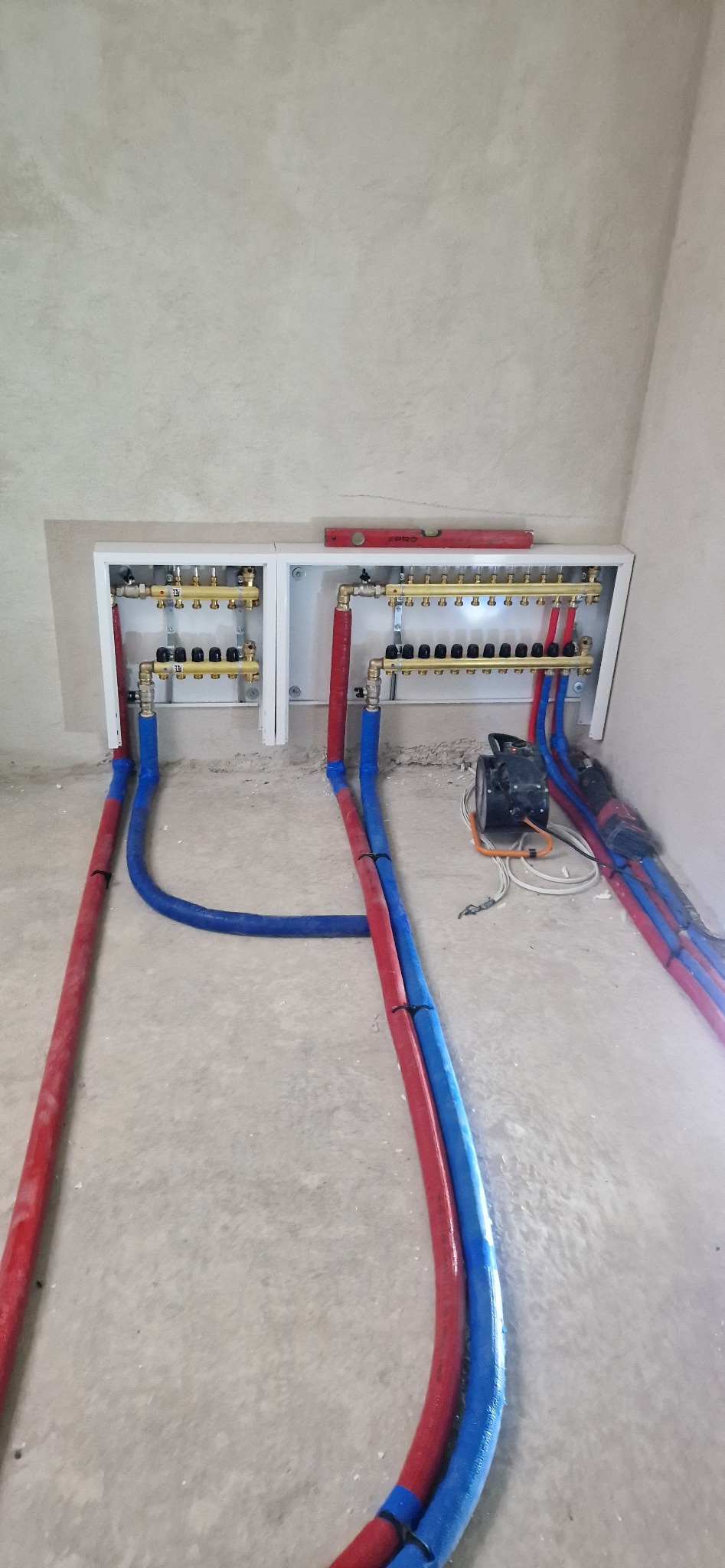 Podłączone zasilenie wraz z powrotem do szfek z rozdzielaczami ogrzewania podłogowego.