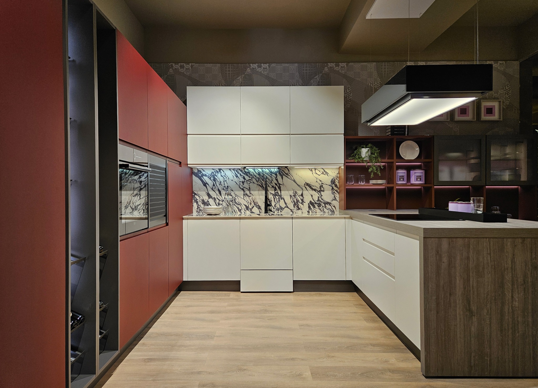 Nowoczesna kuchnia w odcieniach czerwieni, bieli i drewna, z marmurowym backsplashiem i minimalistycznym oświetleniem podszafkowym.