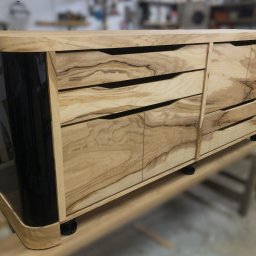 Komoda według indywidualnego projektu, wykonana przez nas z płyty meblowej fornirowanej oliwką. Boki lakierowane na wysoki połysk.