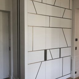 Szafa wnękowa z lakierowanymi frontami. Charakteru nadaje jej ciekawy wzór wykonany przez nas z mosiądzu.