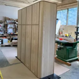 Szafa z zaokrąglonym bokiem wykonana z płyty meblowej fornirowanej dębem.