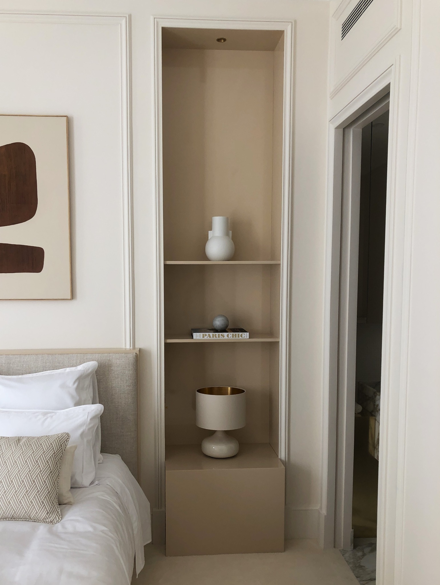 Szafka nocna we wnęce, wykonana z płyty meblowej lakierowanej w połysk.