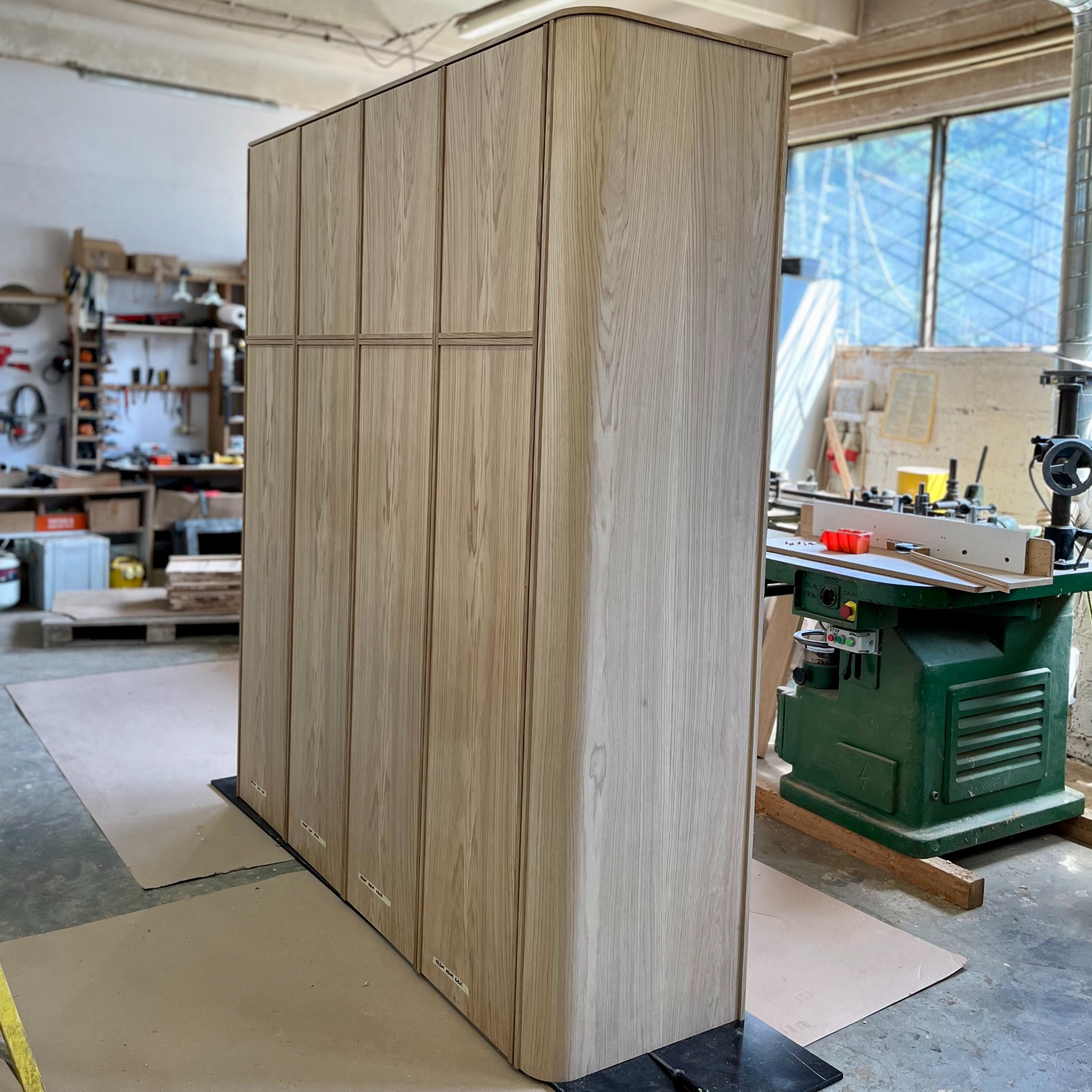 Szafa z zaokrąglonym bokiem wykonana z płyty meblowej fornirowanej dębem.