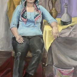 Julia Balon - Olejny portret kobiety w chuście, siedzącej na krześle, obok dzbanka i karafki, z widocznym wiaderkiem malarskim w tle.