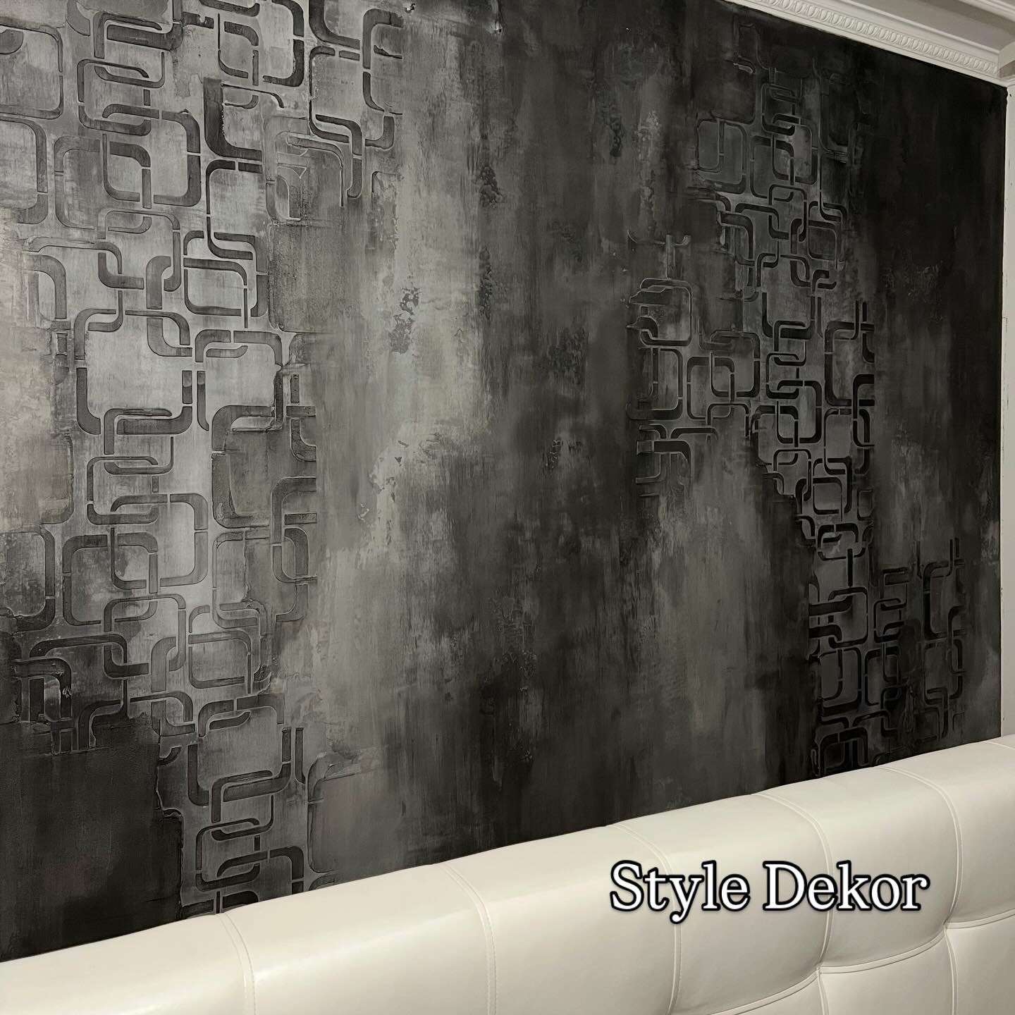 Dekoracyjna ściana w odcieniach szarości z geometrycznym wzorem, widoczna nad wezgłowiem łóżka. Unikalna faktura i artystyczne wykończenie.