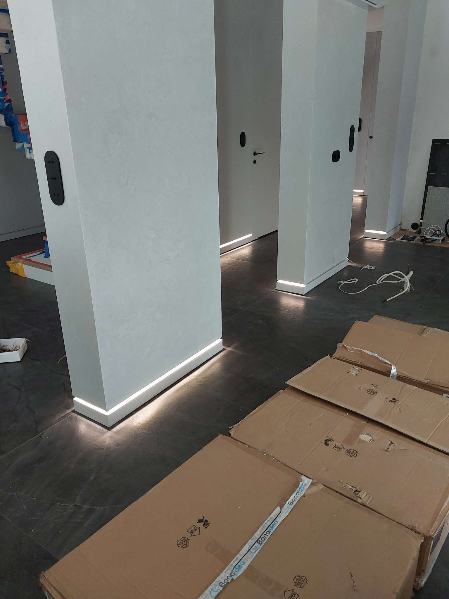 Nowoczesne oświetlenie przypodłogowe LED w biurze we Wrocławiu, widoczne kartony po montażu.