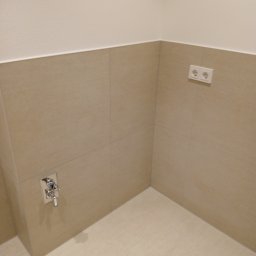 Usługi remontowo budowlane BUDSOB - Beżowe płytki ścienne i podłogowe z zamontowaną baterią umywalkową i gniazdkiem elektrycznym w rogu łazienki.