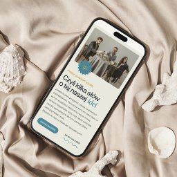 We are SIRIUS - Smartfon wyświetla mobilną wersję strony internetowej z ofertą rybnego concept store, otoczony dekoracyjnymi elementami morskimi na satynowym tle.