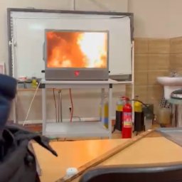 Akademia Reaguj i Ratuj - Symulacja pożaru wyświetlana na ekranie podczas szkolenia, widoczne gaśnice, sala szkoleniowa z umywalką i projektorem.