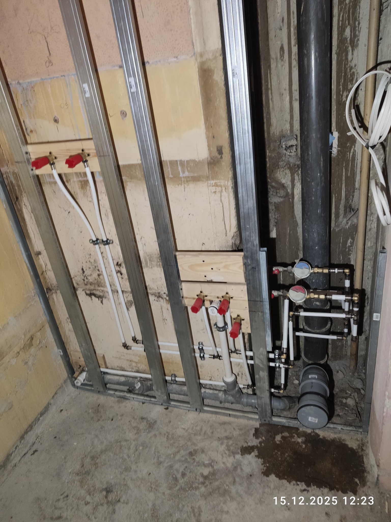 Instalacja wodna i kanalizacyjna w trakcie montażu, widoczne rury i profile w Łodzi. Elementy instalacji częściowo zamontowane, przygotowane do dalszych prac wykończeniowych.