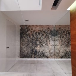 HRS interno sp.zoo - Wnętrze z dekoracyjną tapetą w stylu vintage na ścianie, jasnymi płytkami podłogowymi i minimalistycznymi drzwiami. Widoczne elementy szklane i drewniane.