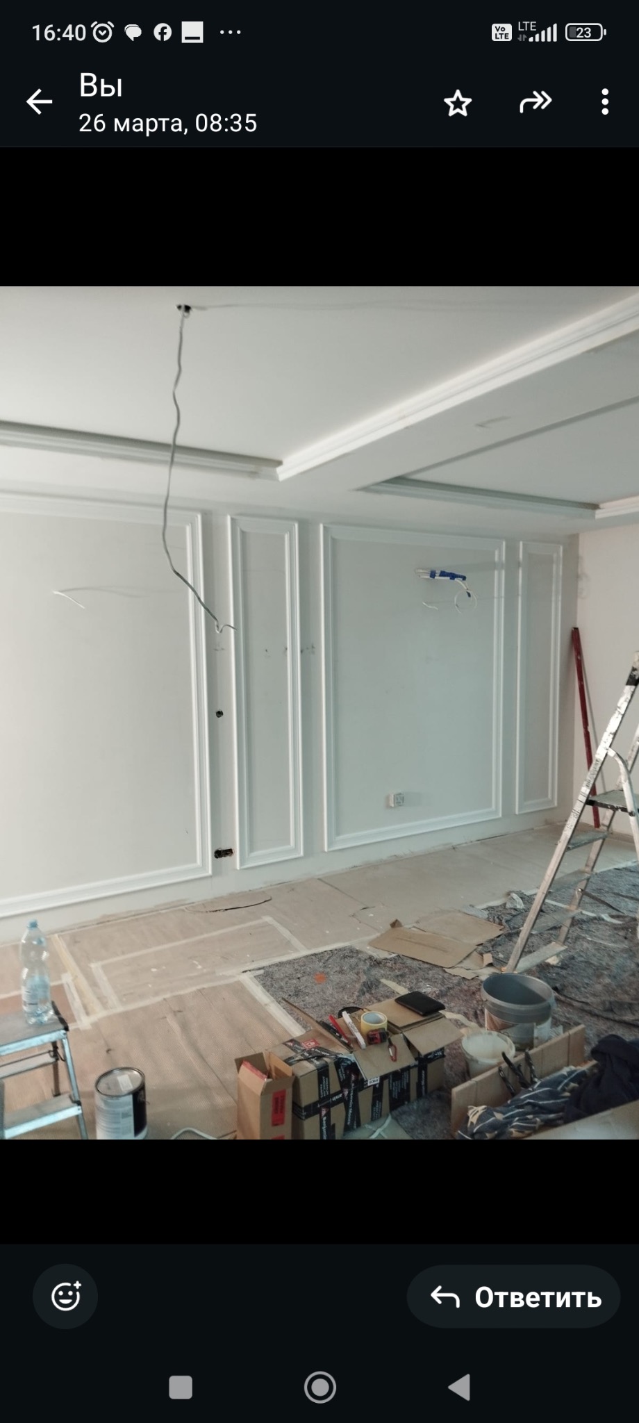 Białe panele dekoracyjne na ścianie w trakcie montażu, widoczne narzędzia i drabina. Sufit z dekoracyjnymi wgłębieniami. Wnętrze w trakcie wykańczania.