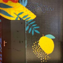 MOZAIKA PLUS SP. z o.o. - Mozaika na ścianie z motywem owoców i roślin, sąsiadująca z czarnymi drzwiami z klamką.