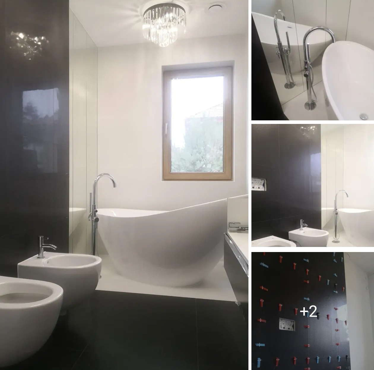 Nowoczesna łazienka w bieli i czerni z wolnostojącą wanną, bidetem i oknem. Kryształowy żyrandol dodaje elegancji. Widoczne detale wykończenia ścian.