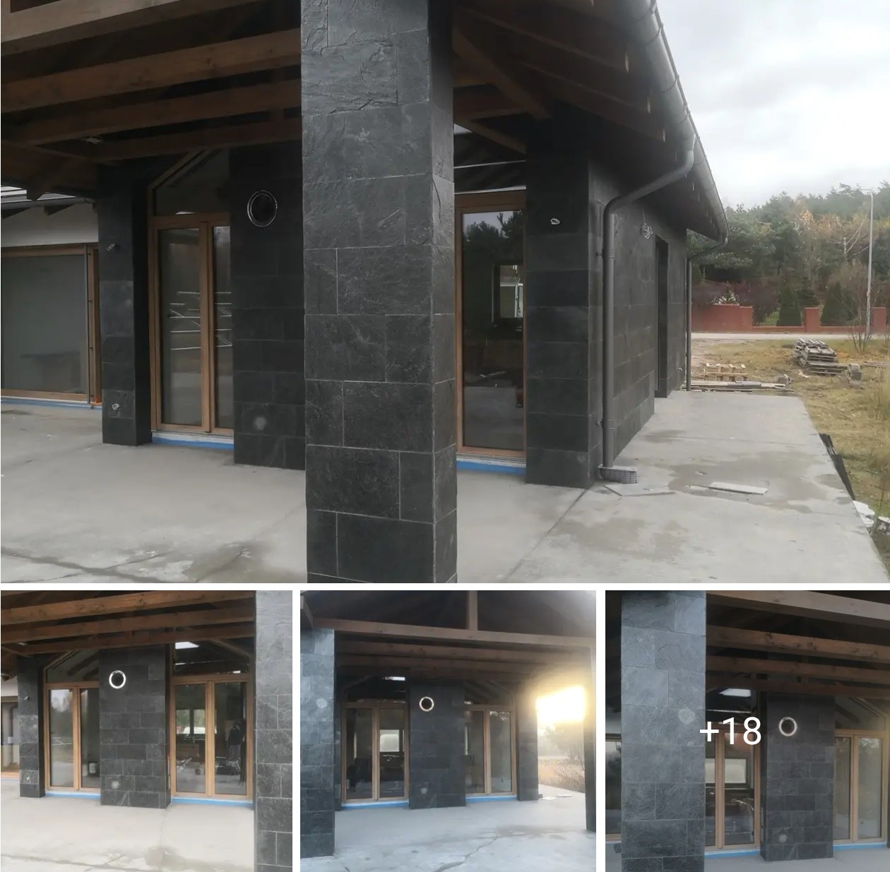 Elewacja domu wykończona czarną, łupkową okładziną. Widoczne drewniane elementy konstrukcyjne dachu i duże okna z drewnianą stolarką. Minimalistyczny styl.