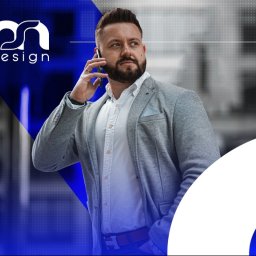 MS Design Maciej Sobczak - Mężczyzna w szarej marynarce rozmawia przez telefon, w tle widoczne logo 'mn design' na niebieskim tle.
