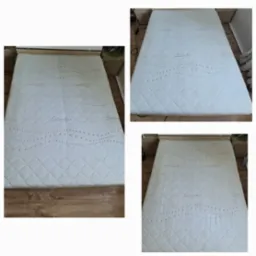 Zdjęcie przedstawia biały materac z wzorem w romby i szarymi zdobieniami, leżący na drewnianym łóżku. Widoczne trzy ujęcia materaca z różnych perspektyw. Na jednym ujęciu w tle widać szafkę nocną.