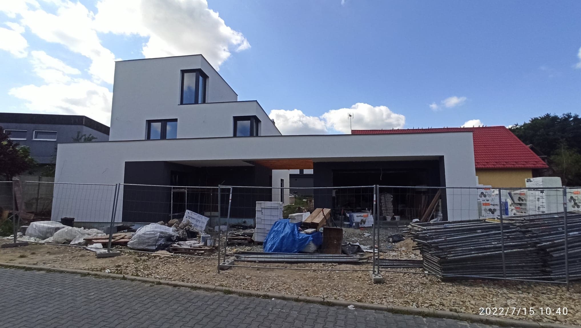 Budowa nowoczesnego domu jednorodzinnego w Żytnie na etapie fundamentów i stanu surowego, widoczne materiały budowlane i tymczasowe ogrodzenie.