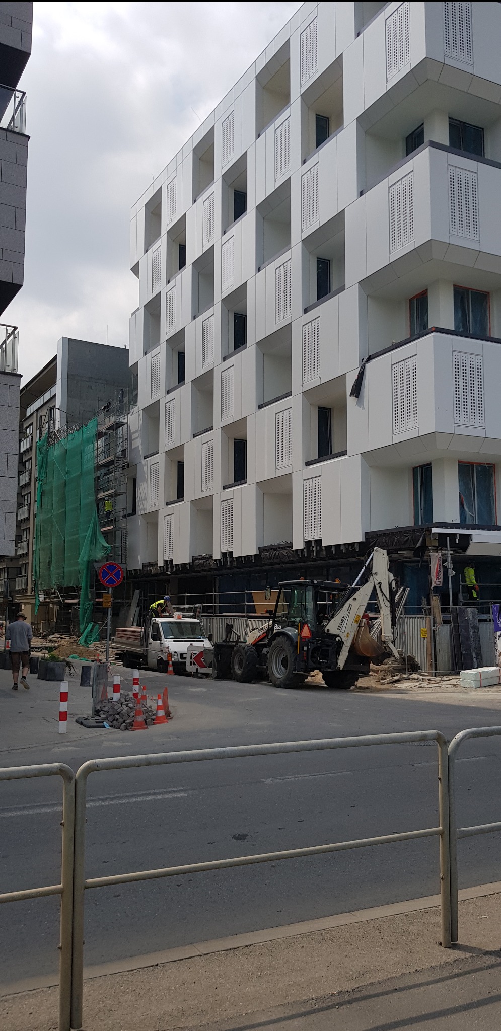 Budynek w trakcie budowy w Liszkach, widoczny sprzęt budowlany i rusztowania.