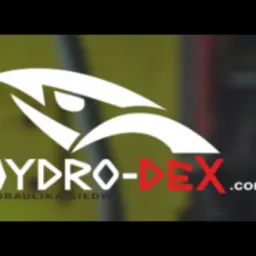 Logo firmy Hydro-Dex z motywem graficznym przypominającym oko, specjalizującej się w hydraulice siłowej, na rozmytym tle warsztatu.