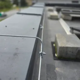 Szczegół montażu przewodu odgromowego na dachu budynku w Bytomiu, widoczne mocowania i fragment instalacji.