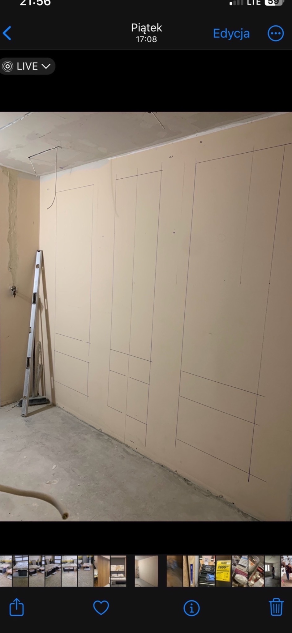 Ściana w trakcie szpachlowania z naniesionymi liniami pod zabudowę, widoczna drabina i narzędzia, surowy stan wykończenia wnętrza.