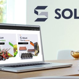 Epiar.pl - Laptop wyświetla stronę internetową firmy Solan z ofertą maszyn rolniczych i pokryć dachowych, na drewnianym biurku obok filiżanki kawy i dzbanka do mleka, w tle widok z okna.