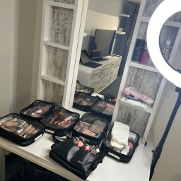 Makeup - Stanowisko do makijażu w Warszawie: torby z kosmetykami ZUCA, pędzle MyKitCo, lampa pierścieniowa i lustro z półkami.